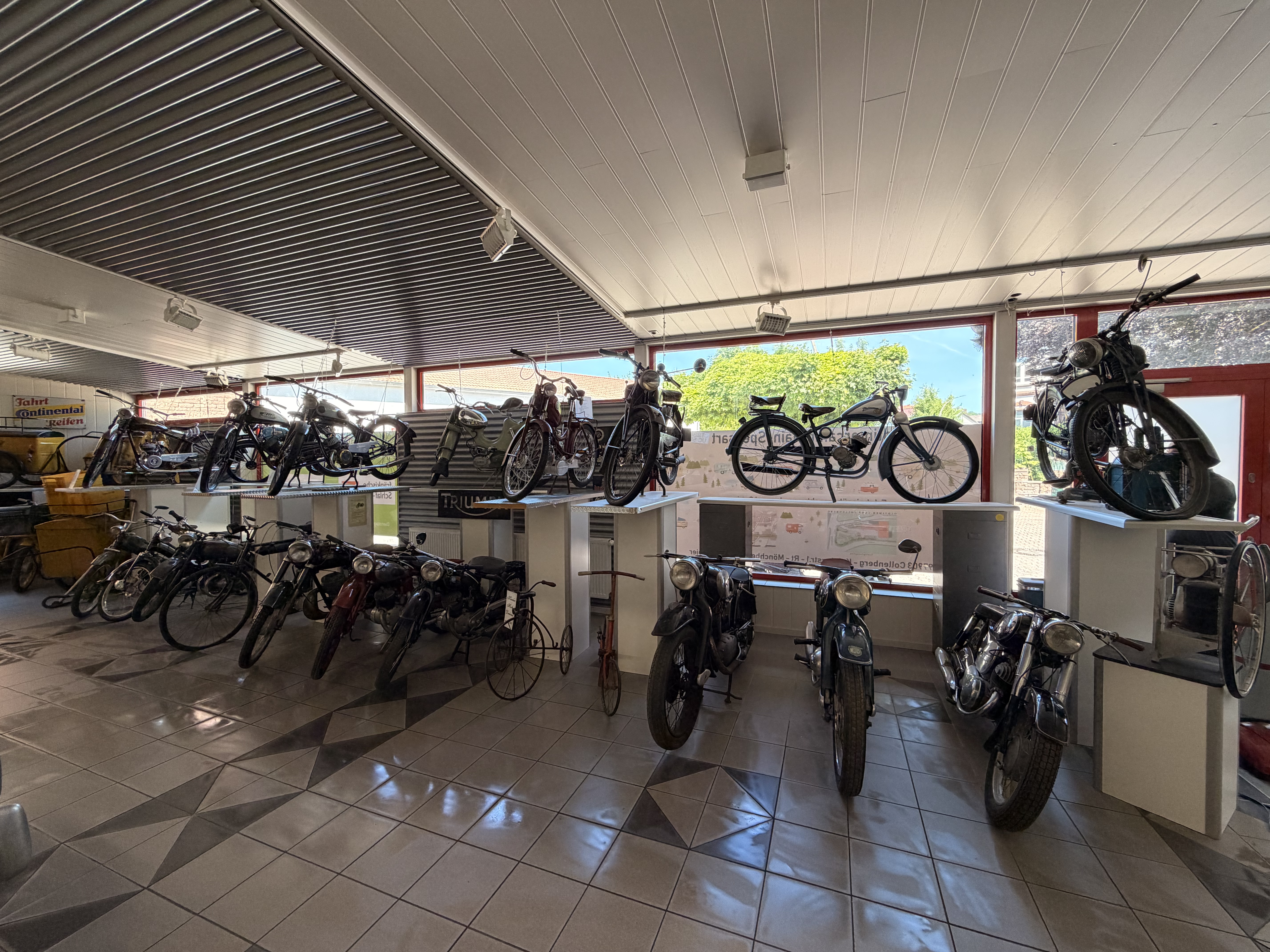 Lange Reihe historischer Motorräder in der Halle
