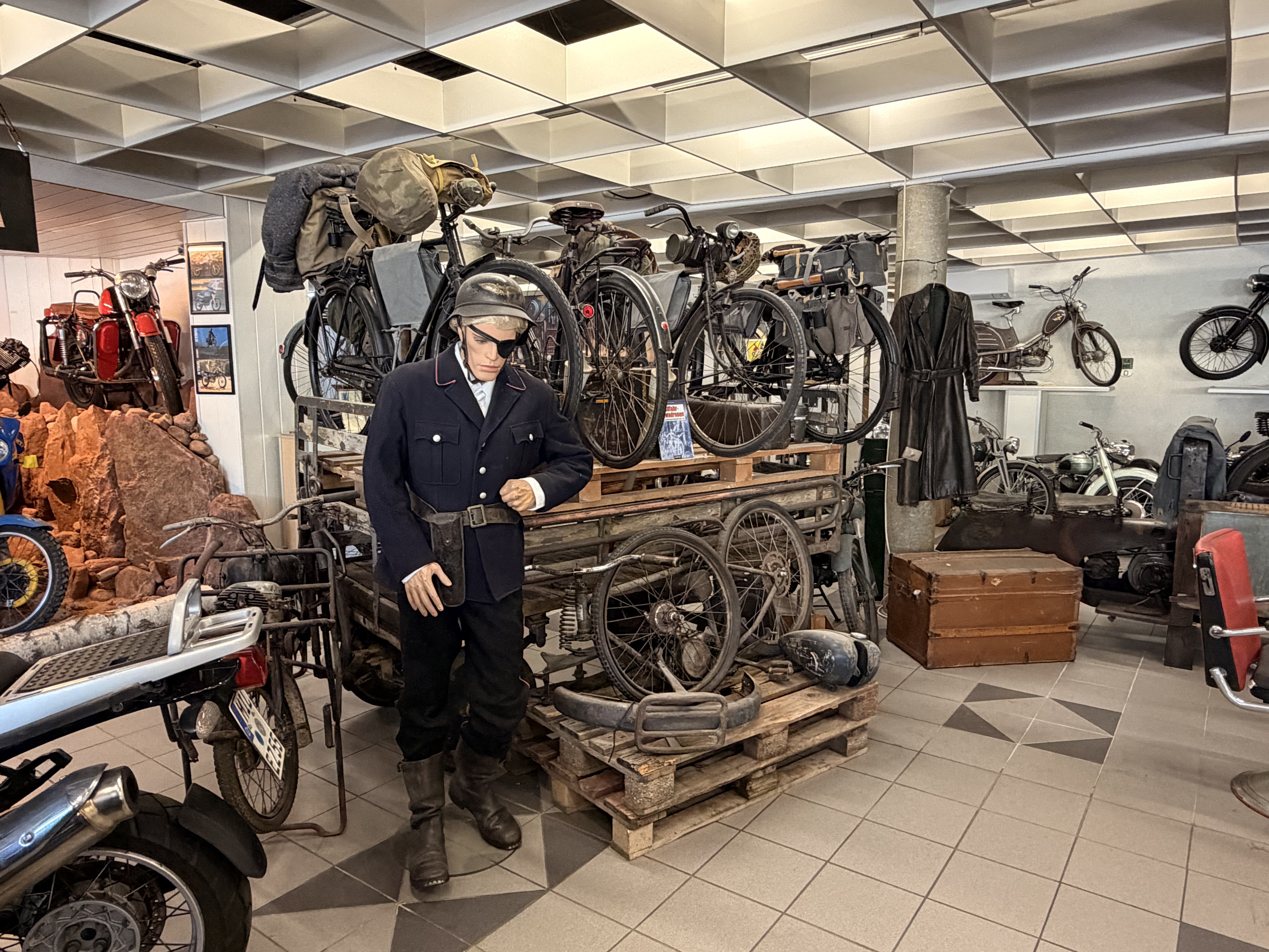 Werkstattszene mit historischen Motorfahrrädern